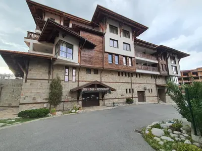 a large wooden building with a lot of windows at Family apartment VYANI in Bansko