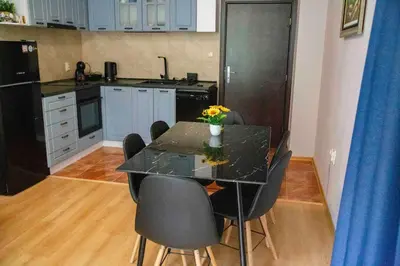 a kitchen with a dining table with chairs and a counter at Forest Dream Apartment - Elit Pamporovo in Pamporovo