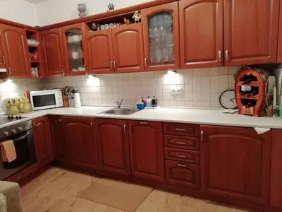 a kitchen with wooden cabinets and a sink at Къща в центъра на Стрелча, джакузи с минерална вода in Strelcha