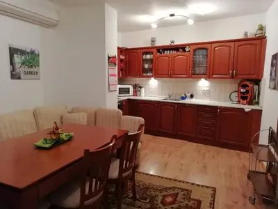 a kitchen with red cabinets and a wooden table at Къща в центъра на Стрелча, джакузи с минерална вода in Strelcha