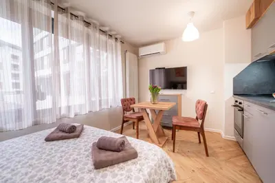 a bedroom with a bed and a table and chairs at WOW studios for rent 2 bul Montevideo 25A - B in Sofia