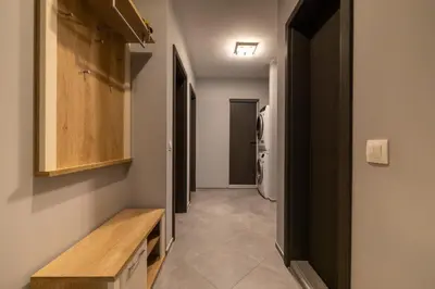 a hallway with a toilet and a wooden bench at Apartment City Home in Sofia