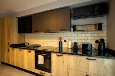 a kitchen with wooden cabinets and a black counter top at Apartment City Home in Sofia