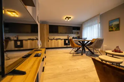 a living room with a table and a kitchen at Apartment City Home in Sofia