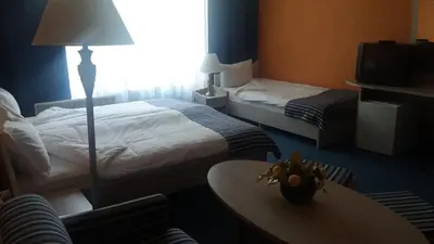 a hotel room with two beds and a table at Hotel Perfect in Yamna
