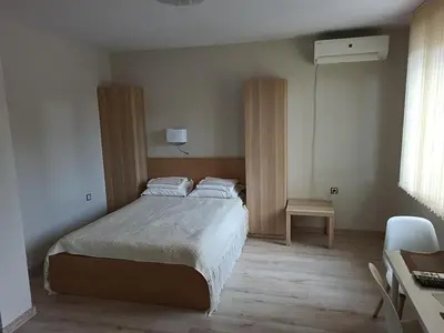 a bedroom with a bed and a desk and a chair at Студиа Студенец in Smolyan