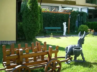 a statue of a kangaroo next to a wooden bench at Семеен Хотел Надежда in Razlog