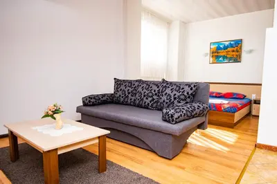 a living room with a couch and a table at Семеен Хотел Надежда in Razlog