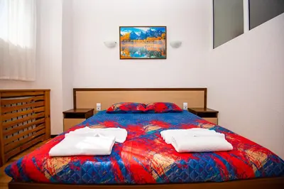 a bedroom with a bed with two towels on it at Семеен Хотел Надежда in Razlog