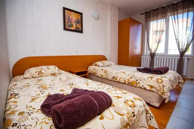 a hotel room with two beds with towels on them at Семеен Хотел Надежда in Razlog