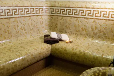 a small bed in a room with towels on it at Hotel Astrea in Hisarya