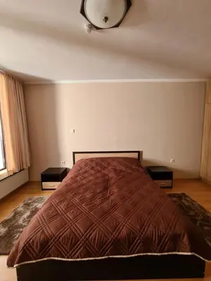 a bedroom with a bed and a clock on the wall at Родопски Рай in Pamporovo