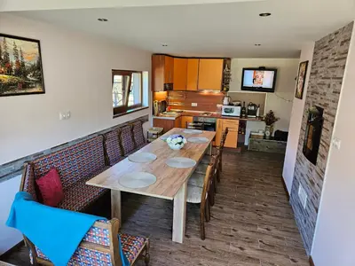 a dining room with a wooden table and chairs at Юндовата къща in Beli Iskar
