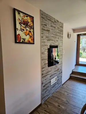 a hallway with a brick wall with a painting on it at Юндовата къща in Beli Iskar