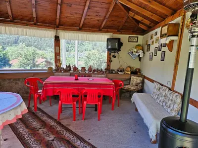 a dining room with a red table and chairs at Юндовата къща in Beli Iskar