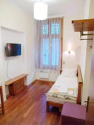 a room with a bed and a tv in it at Balkan Rooms & Studios in Downtown in Sofia