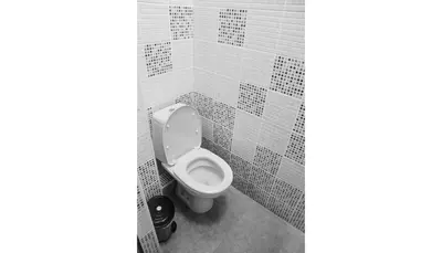 a toilet in a bathroom with white tiles at Balkan Rooms & Studios in Downtown in Sofia
