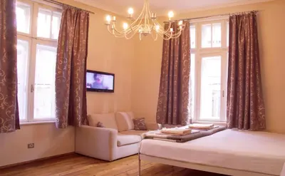 a living room with a couch and a chandelier at Balkan Rooms & Studios in Downtown in Sofia