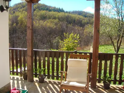a chair sitting on a porch with a view at Family Hotel and Restaurant Plamena in Oreshak