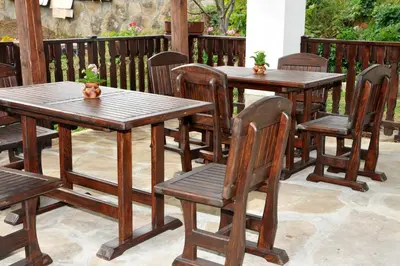 a group of wooden tables and chairs on a patio at Family Hotel and Restaurant Plamena in Oreshak