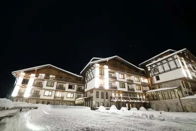 a large building in the snow at night at Green life Bansko, 1 bedroom private apartment D4 in Bansko