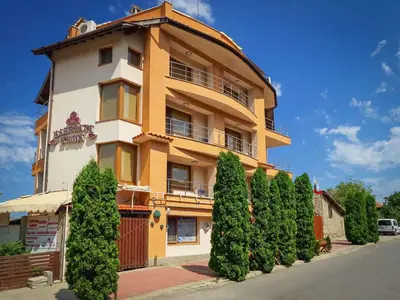 a tall building with trees in front of it at СЕМЕЕН ХОТЕЛ ИЛИЕВАТА КЪЩА in Sapareva Banya