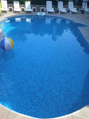 a swimming pool with a beach ball in the water at СЕМЕЕН ХОТЕЛ ИЛИЕВАТА КЪЩА in Sapareva Banya