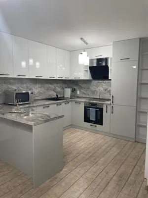 a kitchen with white cabinets and a wooden floor at Emily & Nasi in Plovdiv