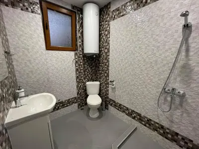 a bathroom with a toilet and a sink and a shower at Guest House Marchini in Sapareva Banya