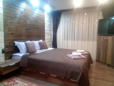 a bedroom with a large bed and a flat screen tv at КръчмЪ При Байката in Ribarica