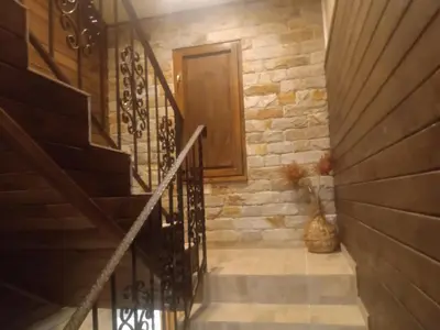 a staircase with a wooden door and a stone wall at КръчмЪ При Байката in Ribarica
