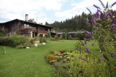 a house with a yard with flowers in front of it at Ski & Spa Chalet Bansko in Bansko