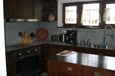 a kitchen with wooden cabinets and a counter top at Ski & Spa Chalet Bansko in Bansko