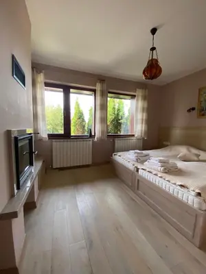 a bedroom with a large bed and a tv at Kameno in Banya
