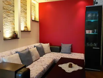 a living room with a couch against a red wall at Apartment Nicole in Plovdiv