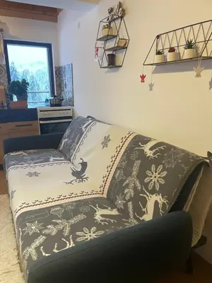 a couch sitting in a living room with a blanket at Stoykite Escape House in Stoykite