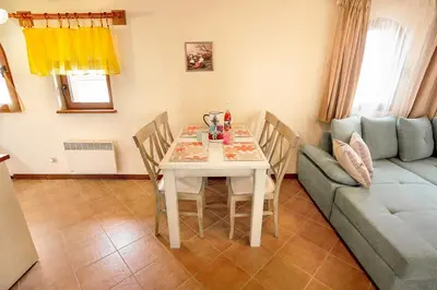 a living room with a table and a couch at Mountain View Pirin Golf in Bansko