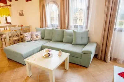 a living room with a blue couch and a table at Mountain View Pirin Golf in Bansko