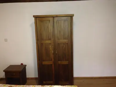a wooden cabinet in the corner of a room at Ristevata Guest House in Kovachevitsa