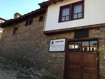 a building with a wooden door and a sign on it at Ristevata Guest House in Kovachevitsa