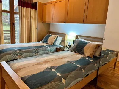 a bedroom with two beds and a window at Wood Apartment in Mountain View Complex in Bansko