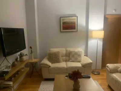 a living room with a couch and a flat screen tv at Wood Apartment in Mountain View Complex in Bansko