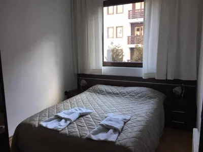 a bedroom with a bed with two towels on it at Fortuna Complex Alexander Services Apartments in Bansko