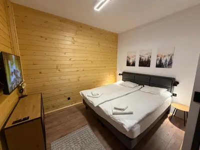 a bedroom with a bed and a flat screen tv at Flora Hotel Apartment 103 in Borovets