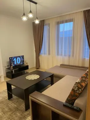 a living room with a couch and a tv at Гранд Манастира , Пампорово in Pamporovo