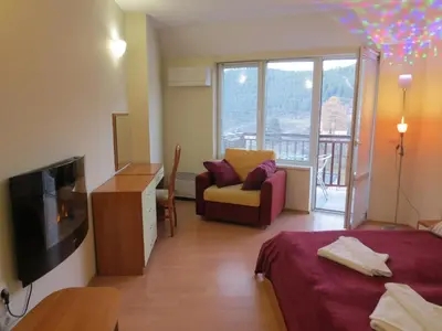 a room with a bed and a tv and a couch at Panoramic Apartment 301 in Eagle Rock Complex in Beli Iskar