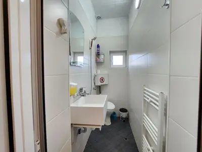 a white bathroom with a sink and a mirror at Villa 