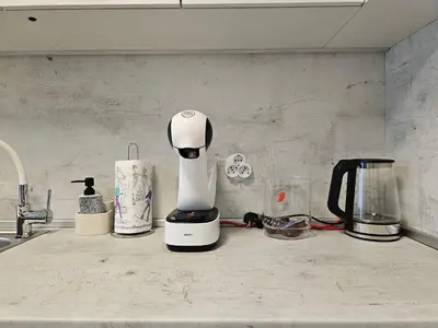a white coffee maker sitting on a kitchen counter at Brand new apartment with free parking near city center in Sofia