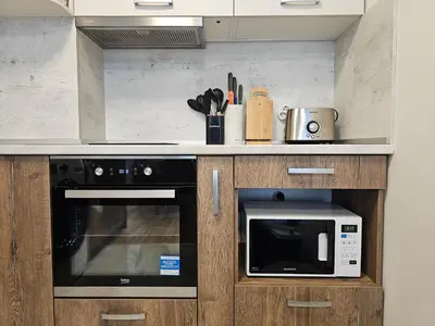 a kitchen with a stove and a microwave at Brand new apartment with free parking near city center in Sofia