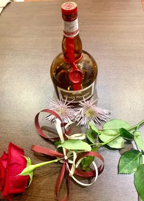 a bottle of wine and flowers on a table at ,,Адела”-апартамент за гости in Velingrad